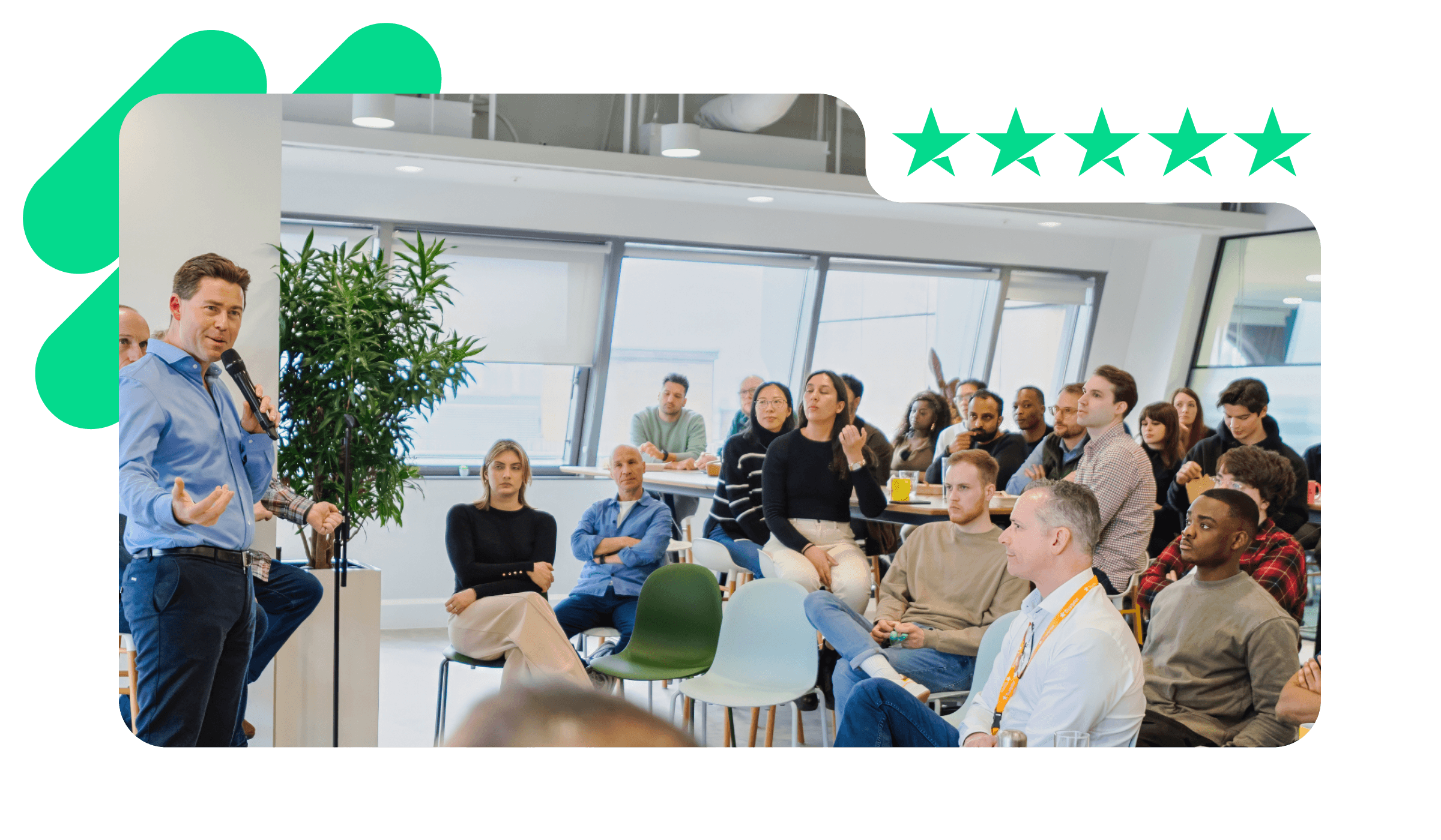 A photo of Adrian Blair, CEO at Trustpilot, presenting in a company meeting