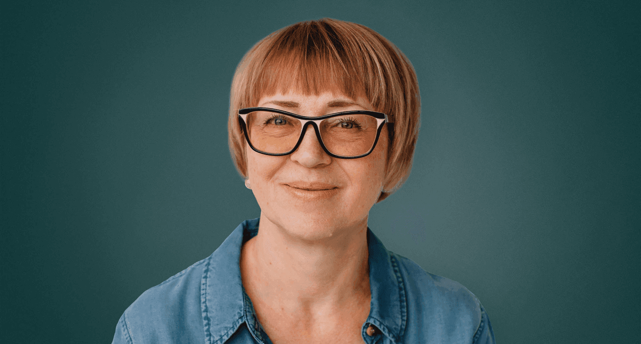 A headshot of a woman with short hair and wearing glasses.